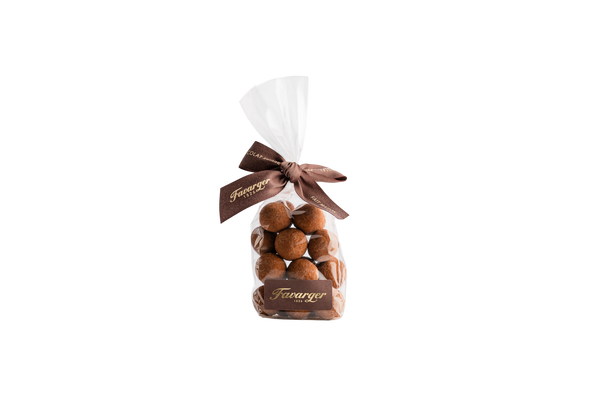 Sachet de 100 g de noisettes entières Favarger enrobées de chocolat noir suisse, alliance gourmande entre le croquant de la noisette et l'intensité du chocolat noir.